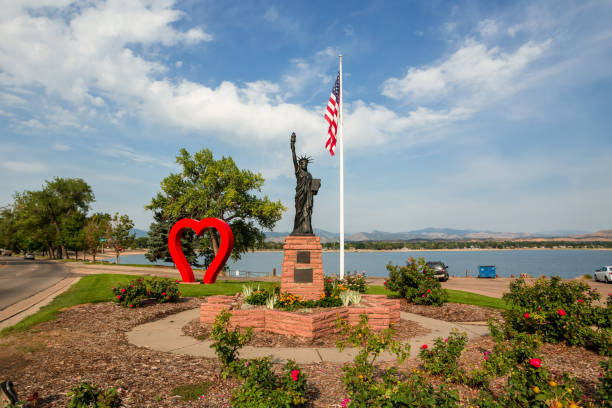 Loveland, Colorado, USA - August 28th, 2020: Red Heart, copy of the Statue of Liberty and American flag in the city park on the Loveland lake shores